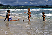 A mother with her two small children on a beach in Martinique